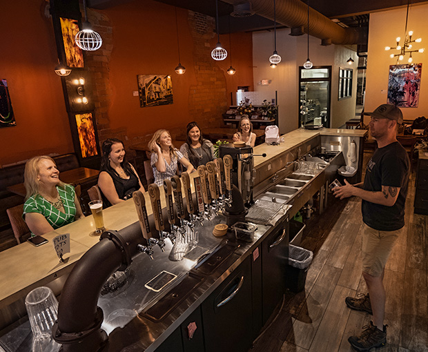 man behind bar serving guests