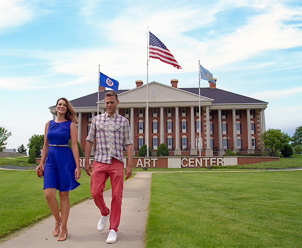 couple holding hands outside redlin art center