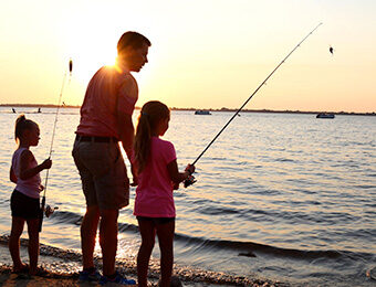 family fishing on shoreline