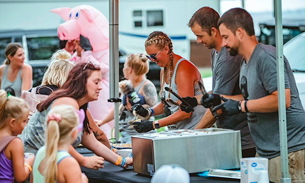 people serving food at a street fair