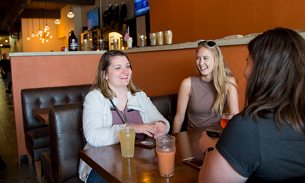 ladies sitting in a booth drinking beer