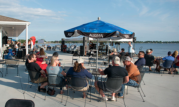 people sitting at the lake under a tent